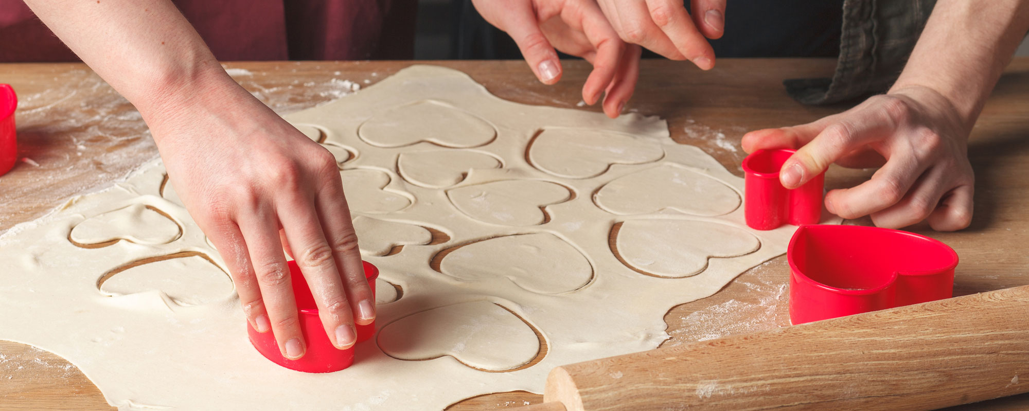 Couple making heart shaped cookies