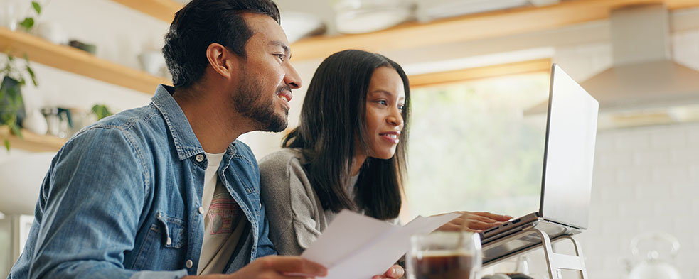 couple looking at finances on paper and laptop